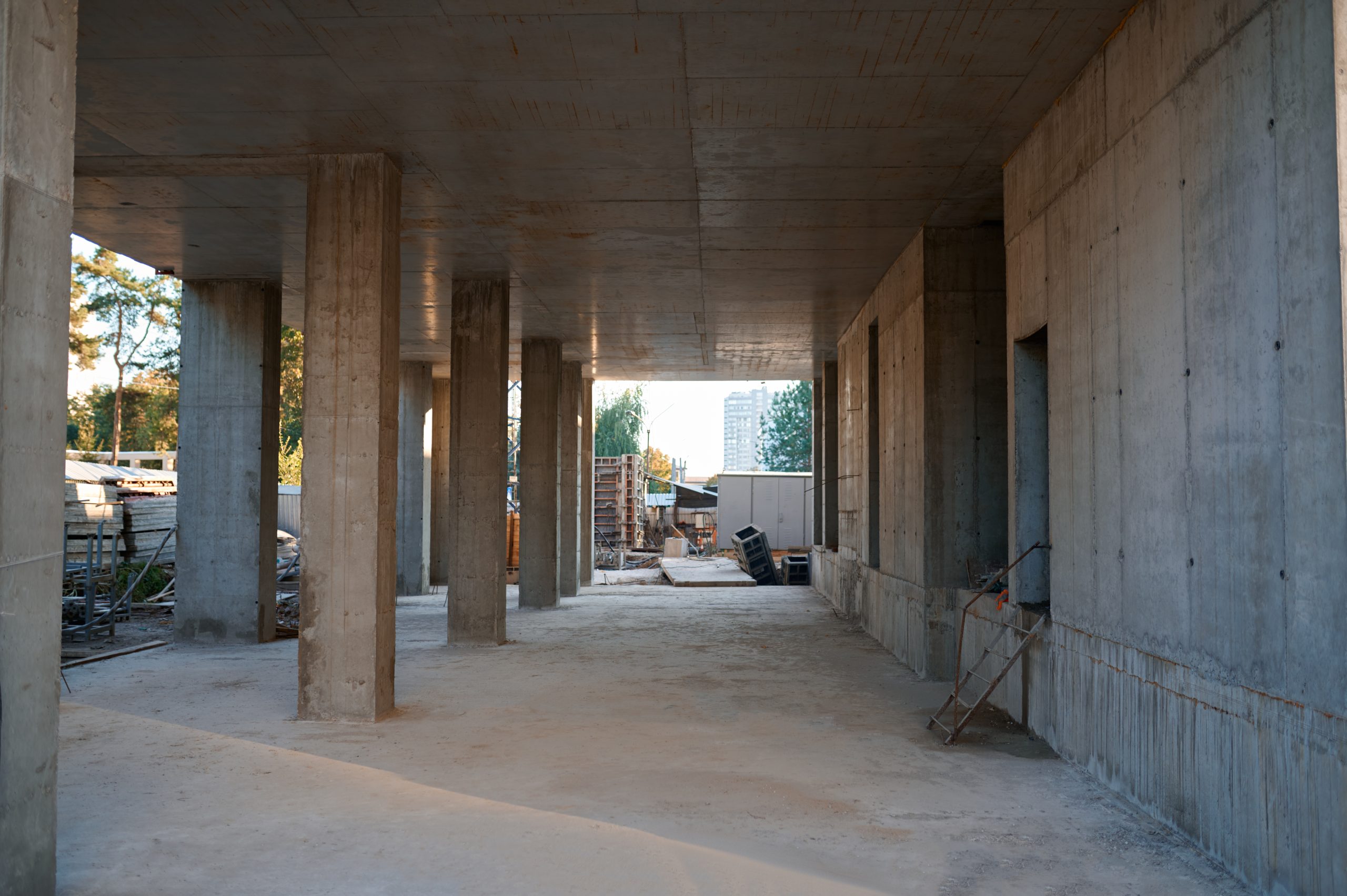 Construction site with view on concrete floor and columns supporting ceiling. No people